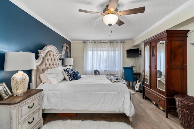 bedroom with ceiling fan, ornamental molding, light hardwood / wood-style floors, and a textured ceiling