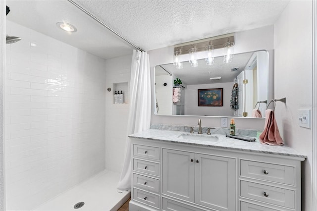 bathroom with a shower with curtain, vanity, and a textured ceiling