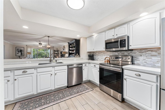 kitchen featuring white cabinetry, sink, kitchen peninsula, and appliances with stainless steel finishes