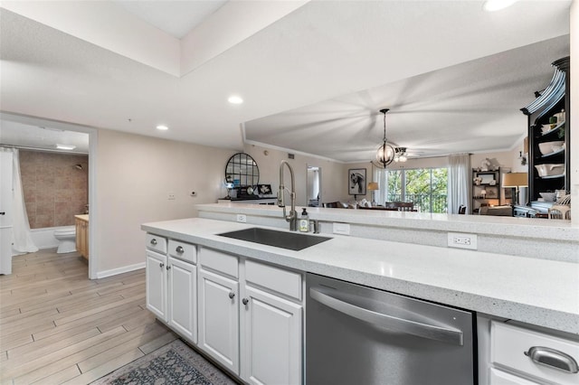 kitchen featuring sink, light wood-type flooring, dishwasher, pendant lighting, and white cabinets