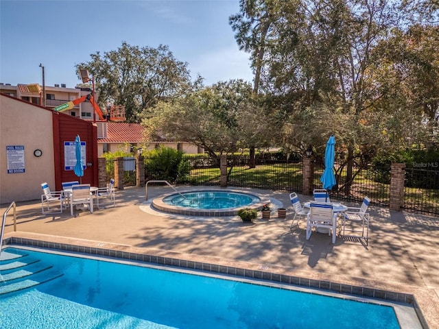 view of swimming pool featuring a community hot tub and a patio area