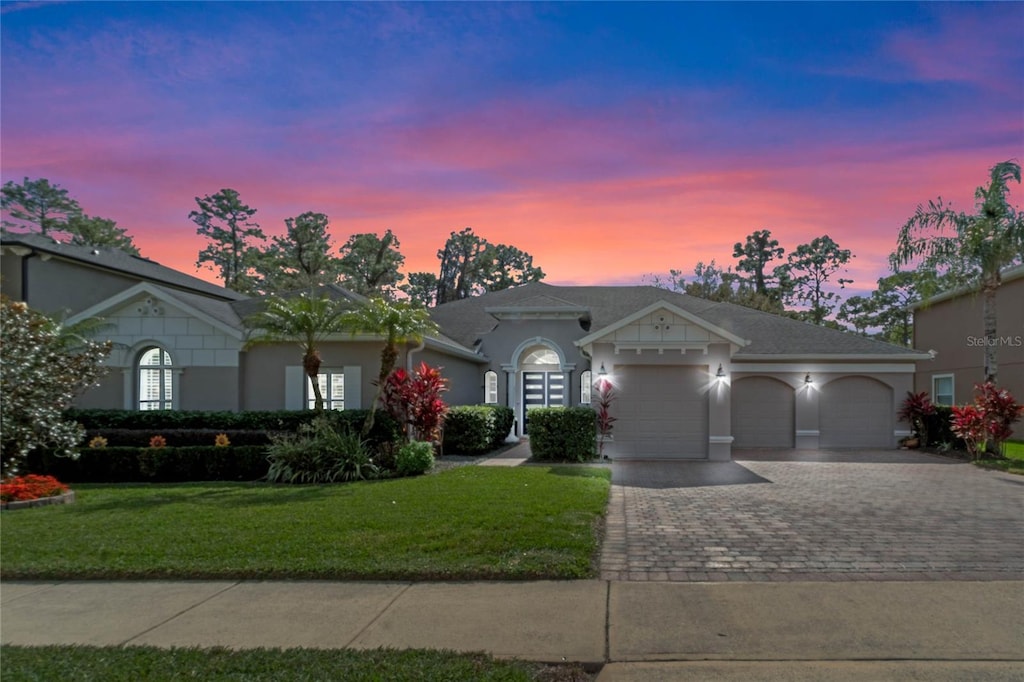 ranch-style house featuring a garage and a yard