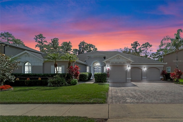 ranch-style house featuring a garage and a yard