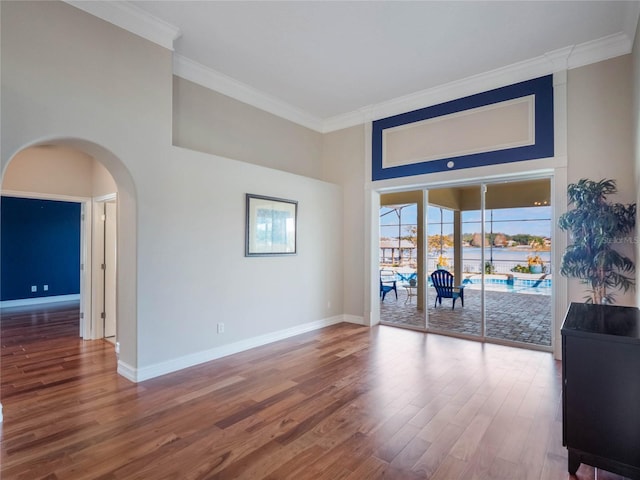 living room featuring crown molding, a towering ceiling, and hardwood / wood-style floors