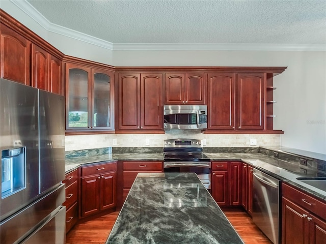 kitchen featuring stainless steel appliances, crown molding, backsplash, and dark hardwood / wood-style flooring