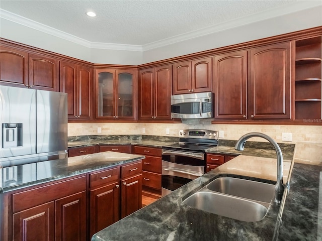 kitchen with stainless steel appliances, tasteful backsplash, sink, and a textured ceiling