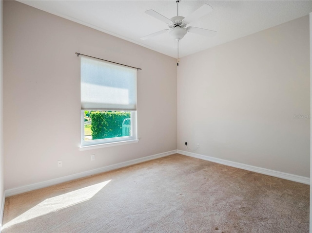 spare room featuring light carpet and ceiling fan