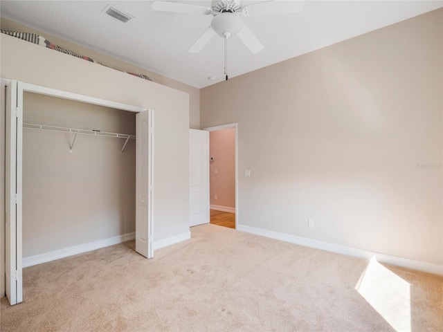 unfurnished bedroom with light carpet, ceiling fan, and a closet