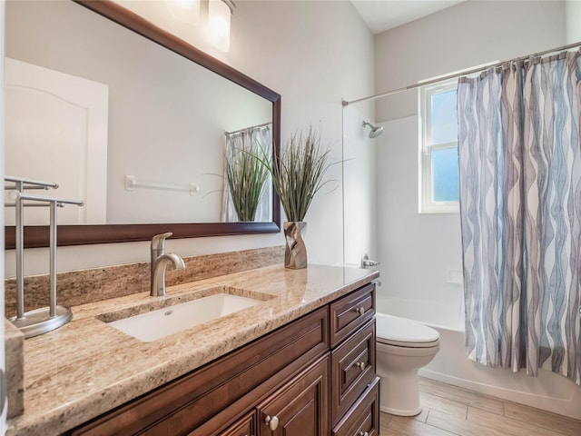 full bathroom featuring hardwood / wood-style flooring, shower / bath combo, vanity, and toilet