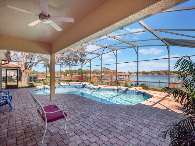 view of pool with a water view, ceiling fan, glass enclosure, and a patio area