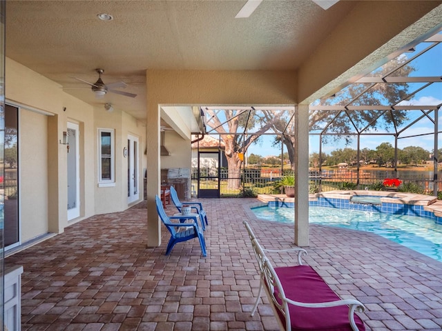 view of patio / terrace with a swimming pool with hot tub, ceiling fan, and glass enclosure