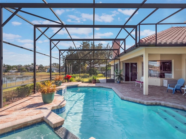 view of pool with a water view, an in ground hot tub, a patio area, and glass enclosure