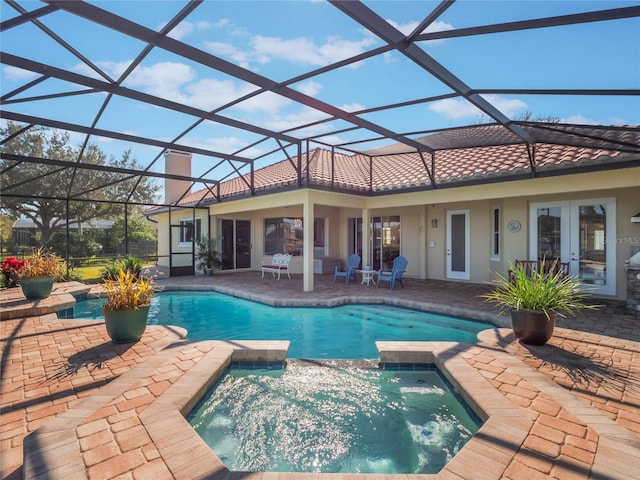 view of pool featuring an in ground hot tub, a lanai, a patio area, and french doors