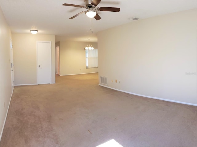 spare room with ceiling fan with notable chandelier and light colored carpet