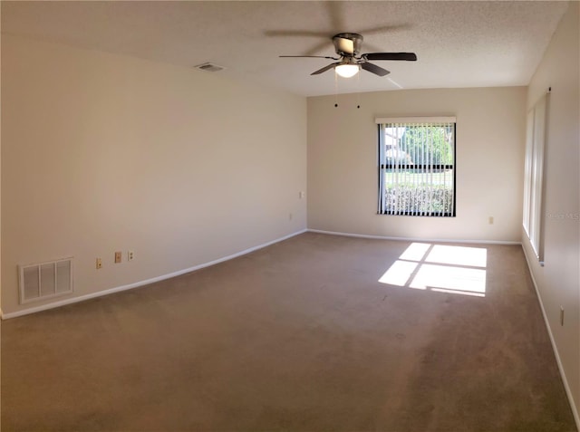 carpeted empty room featuring ceiling fan and a textured ceiling