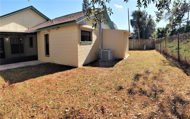 view of side of property featuring a lawn and central air condition unit