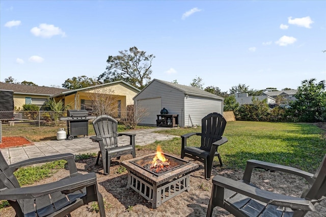 view of patio / terrace with a garage, an outbuilding, and an outdoor fire pit