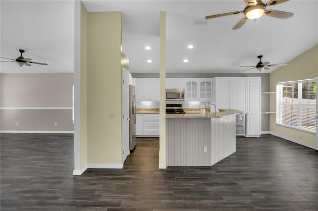 kitchen with sink, white cabinetry, dark hardwood / wood-style flooring, stainless steel appliances, and light stone countertops