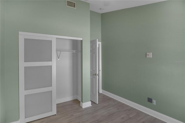 unfurnished bedroom featuring light hardwood / wood-style flooring and a closet