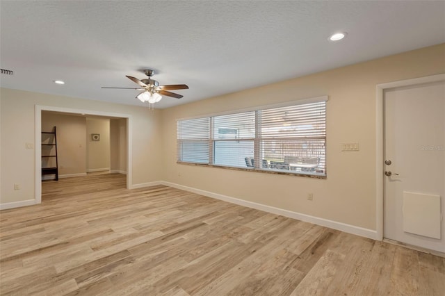 spare room with ceiling fan, a textured ceiling, and light hardwood / wood-style floors