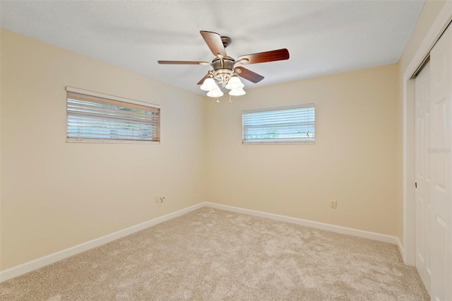 carpeted empty room featuring ceiling fan