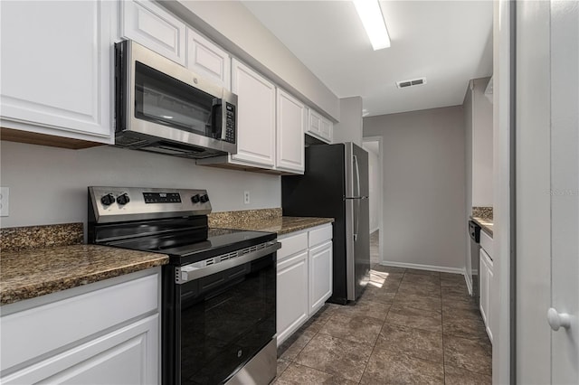 kitchen with dark countertops, visible vents, appliances with stainless steel finishes, white cabinetry, and baseboards