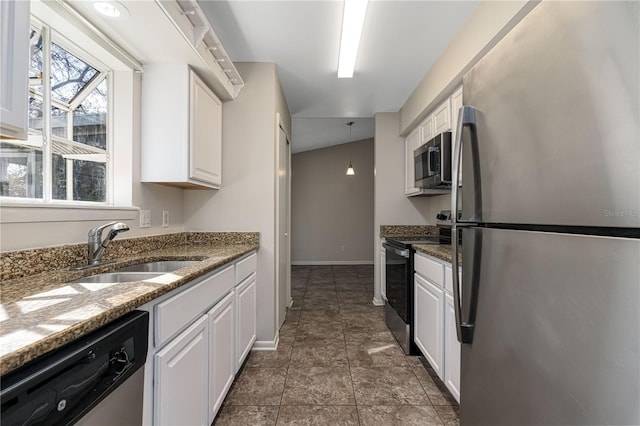 kitchen with stone countertops, stainless steel appliances, a sink, white cabinetry, and baseboards