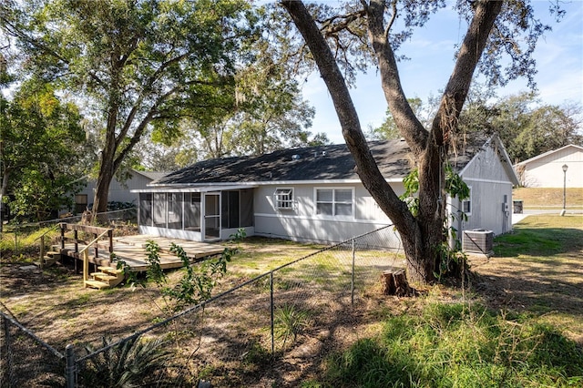 rear view of property featuring a wooden deck, central AC, fence, and a sunroom