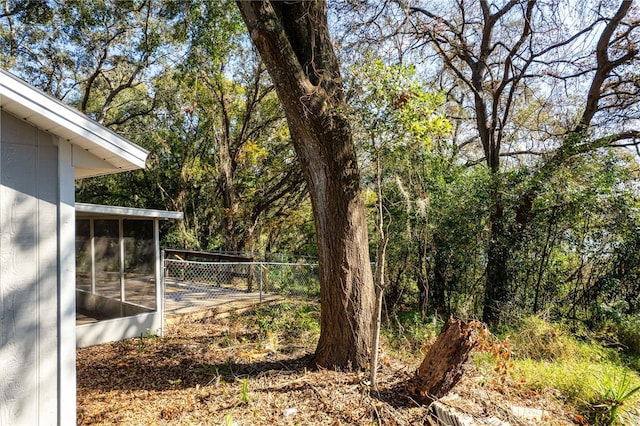 view of yard featuring a sunroom and fence