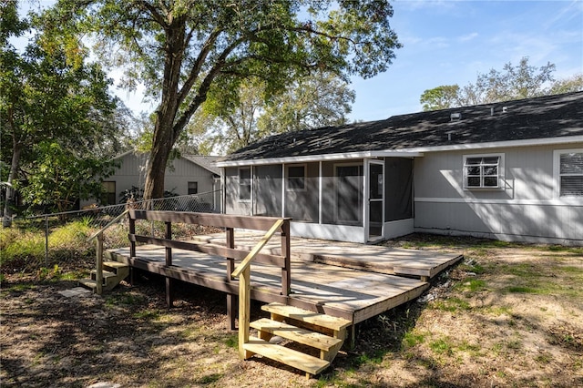 back of property with a sunroom, fence, and a wooden deck