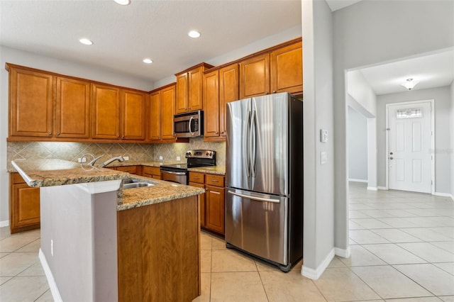 kitchen featuring sink, light tile patterned floors, appliances with stainless steel finishes, light stone countertops, and decorative backsplash