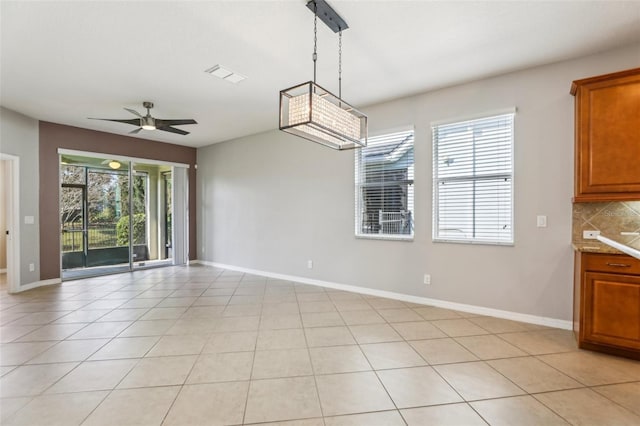 unfurnished dining area featuring ceiling fan and light tile patterned floors