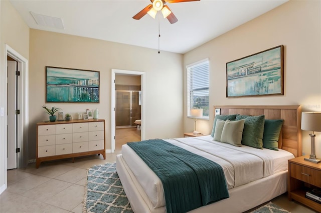 bedroom with light tile patterned flooring, ceiling fan, and connected bathroom