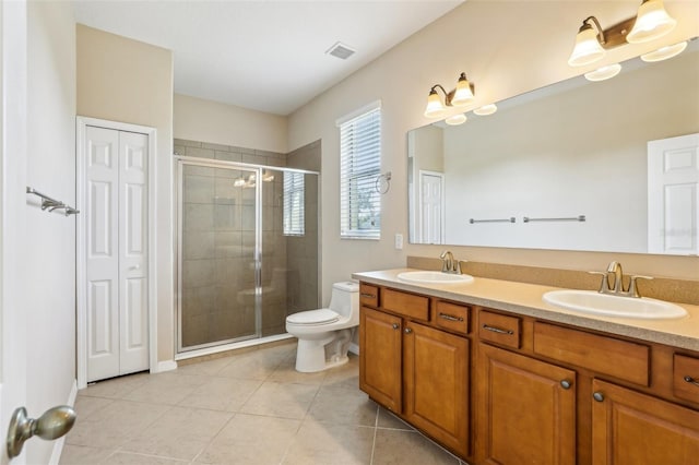 bathroom featuring tile patterned floors, vanity, toilet, and a shower with shower door