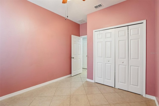 unfurnished bedroom with light tile patterned floors, a closet, and ceiling fan