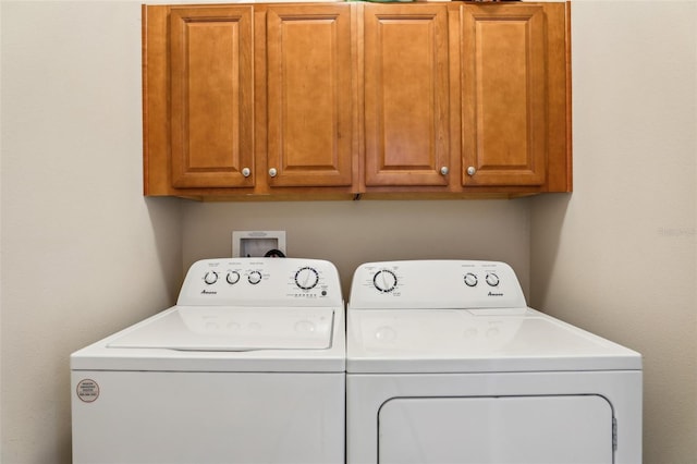 laundry area with cabinets and washing machine and clothes dryer