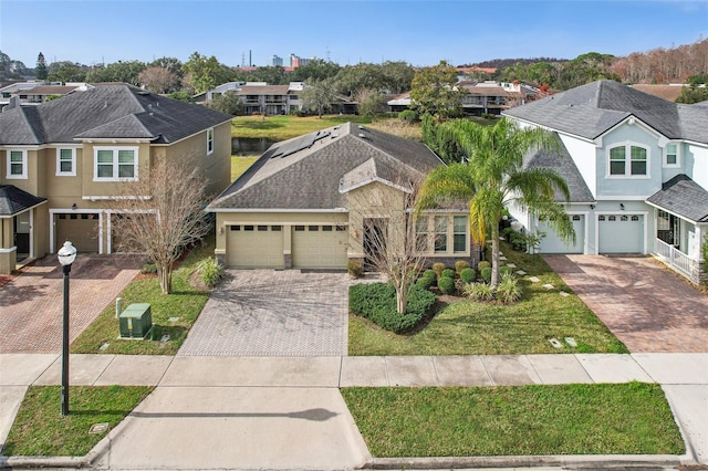 view of front of property with a garage, central AC, and a front lawn