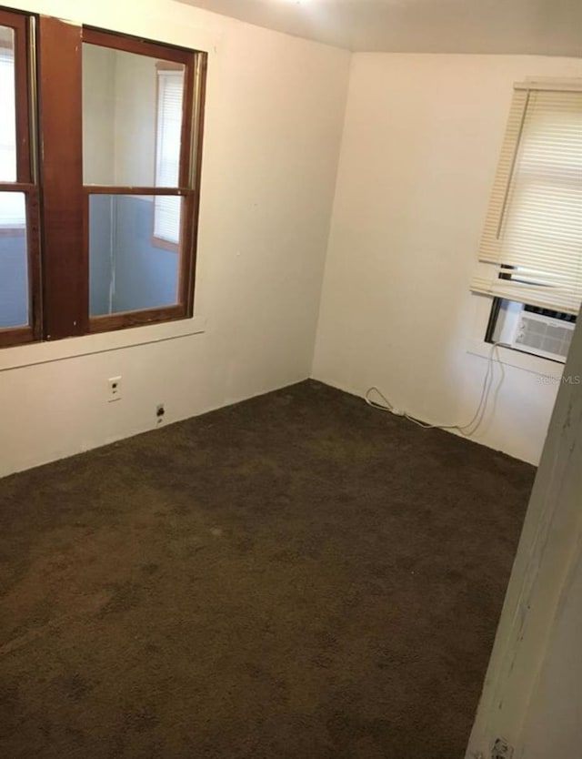 spare room with dark colored carpet