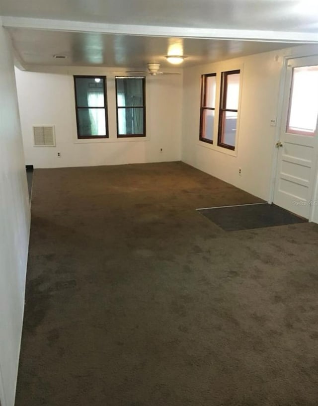 unfurnished room featuring dark carpet