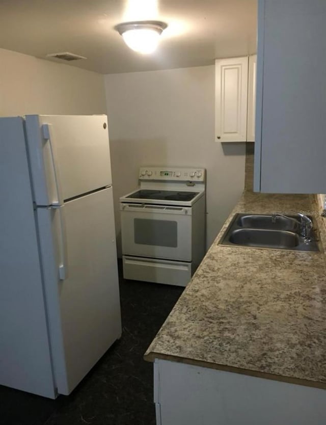 kitchen featuring white cabinetry, white appliances, and sink