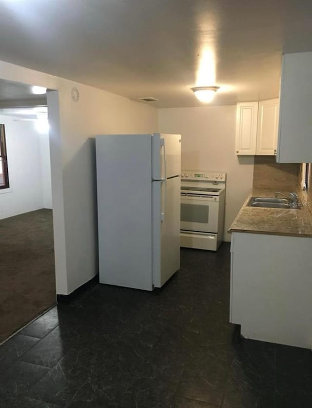 kitchen featuring white cabinetry, sink, and white appliances