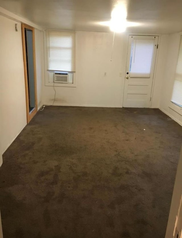 empty room with cooling unit and dark carpet