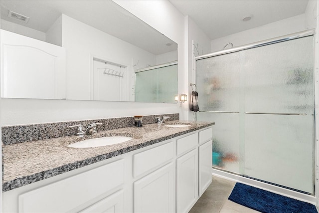 bathroom with a stall shower, visible vents, a sink, and double vanity