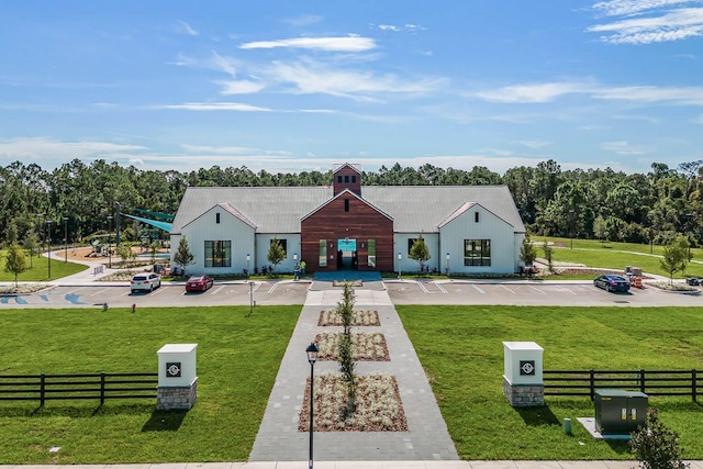 exterior space with fence, metal roof, and a front yard