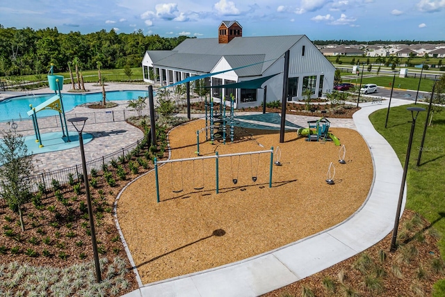 surrounding community with playground community, fence, a swimming pool, and a lawn