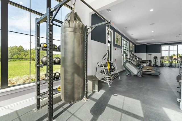 exercise room with ornamental molding, recessed lighting, and visible vents