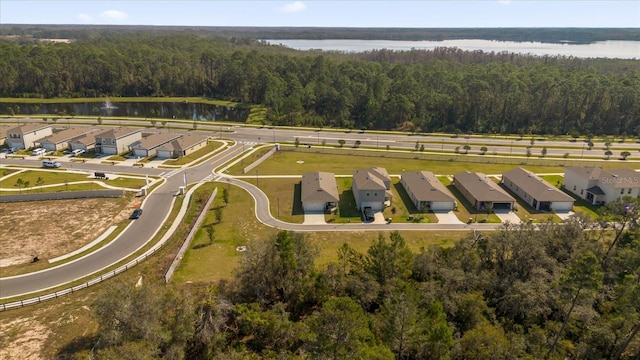 aerial view featuring a forest view, a water view, and a residential view