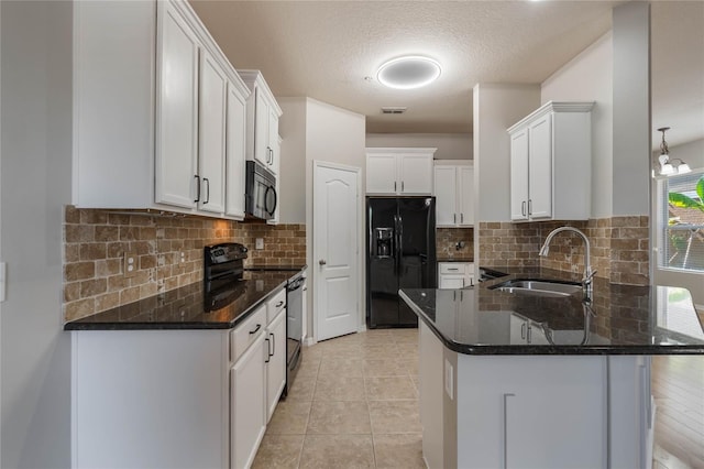 kitchen featuring sink, white cabinetry, dark stone countertops, black appliances, and a kitchen bar