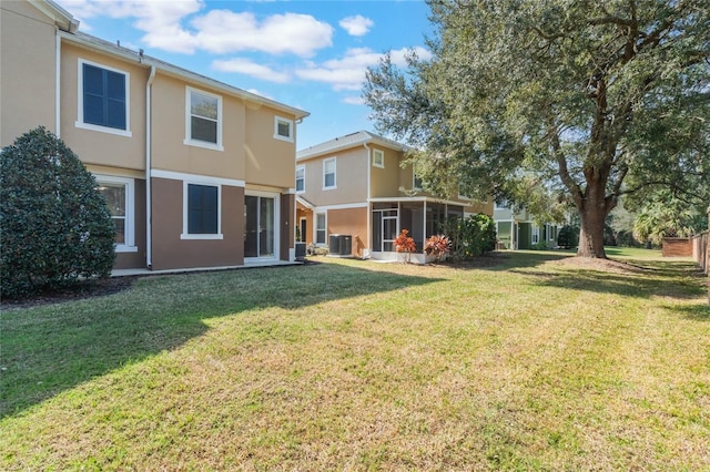 back of property featuring a yard, a sunroom, and central air condition unit