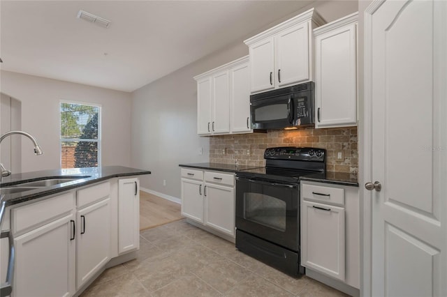 kitchen featuring sink, black appliances, light tile patterned floors, decorative backsplash, and white cabinets